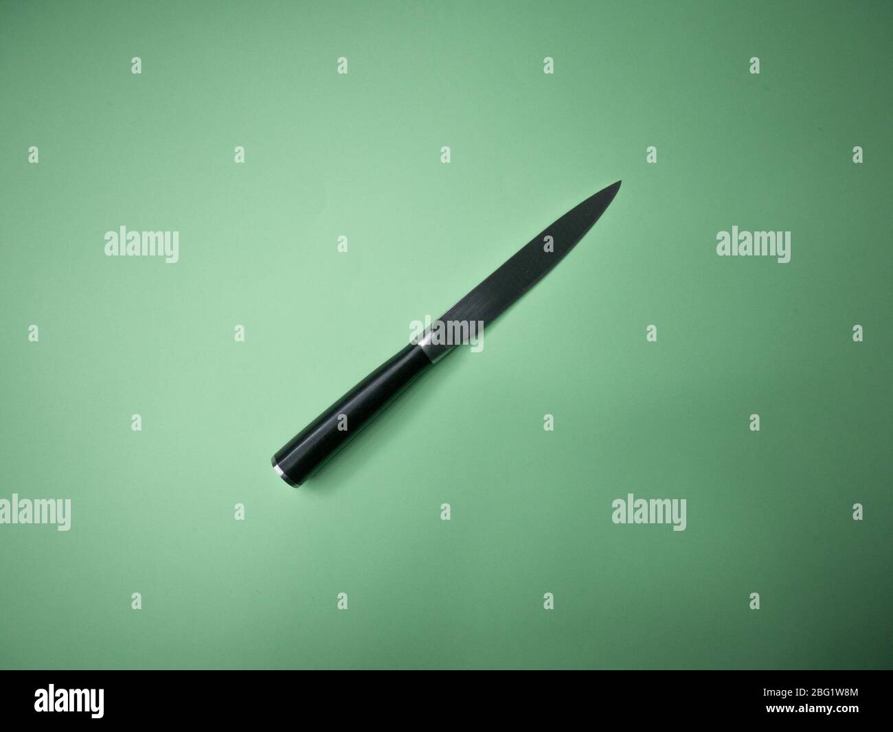 Professional kitchen knife isolated on green background. Stock Photo