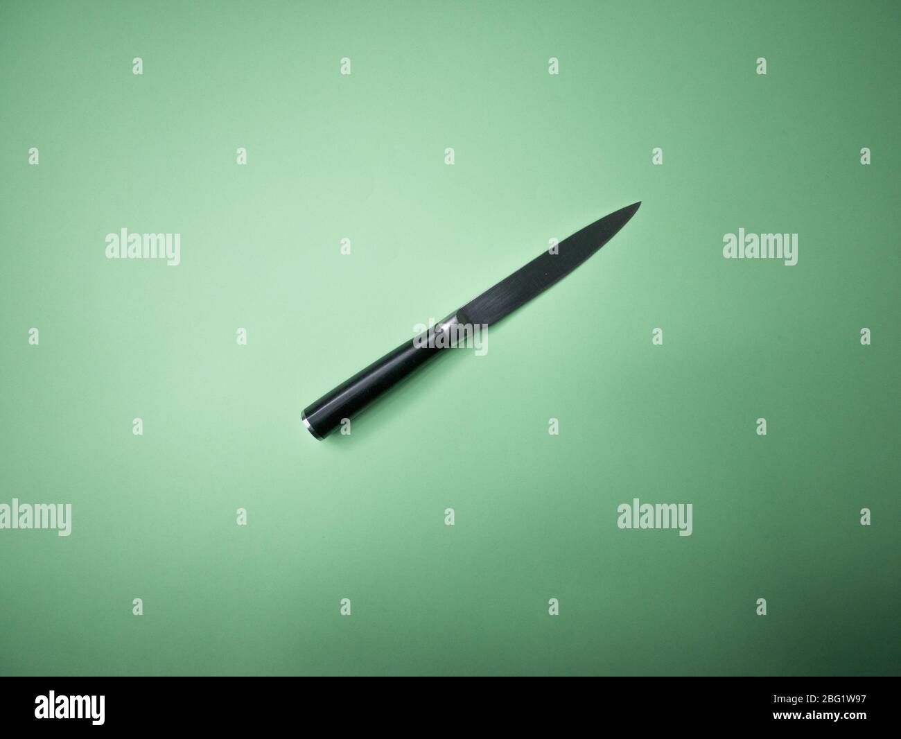 Professional kitchen knife isolated on green background. Stock Photo