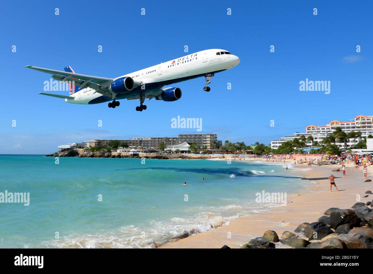 Delta Airlines Boeing 757 about to land in St Maarten airport passing over Maho Beach, famous for the airplanes passing very low. Tourist attraction. Stock Photo