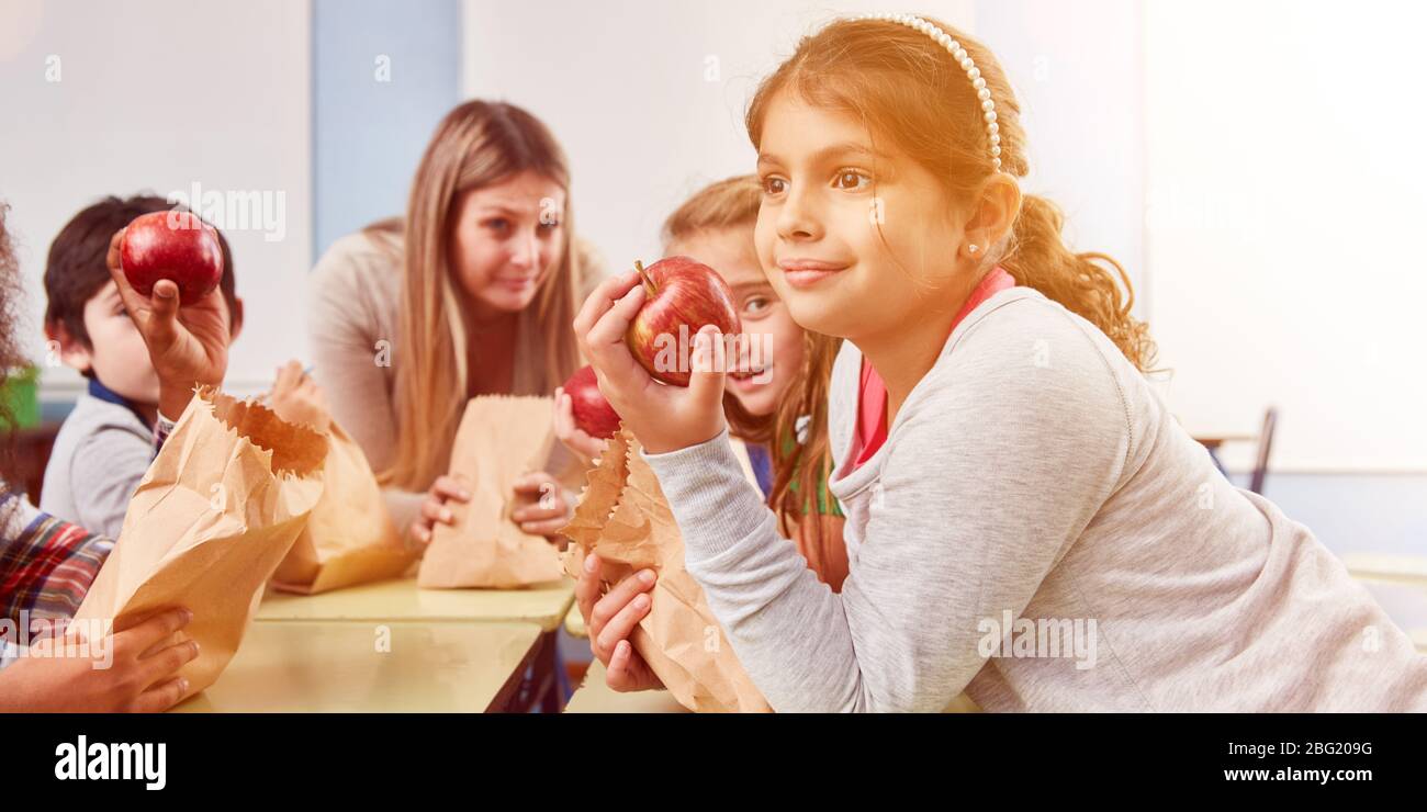 Children eat together fresh fruit as a snack during the break of