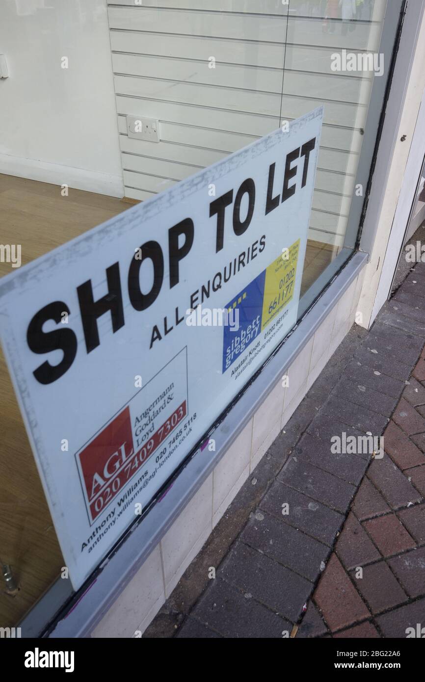 close up of a sign saying shop to let in the window of an empty shop Stock Photo