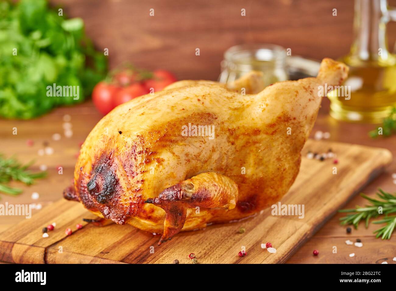 https://c8.alamy.com/comp/2BG22TC/whole-roasted-chicken-on-wooden-cutting-board-on-dark-brown-wooden-table-side-view-2BG22TC.jpg