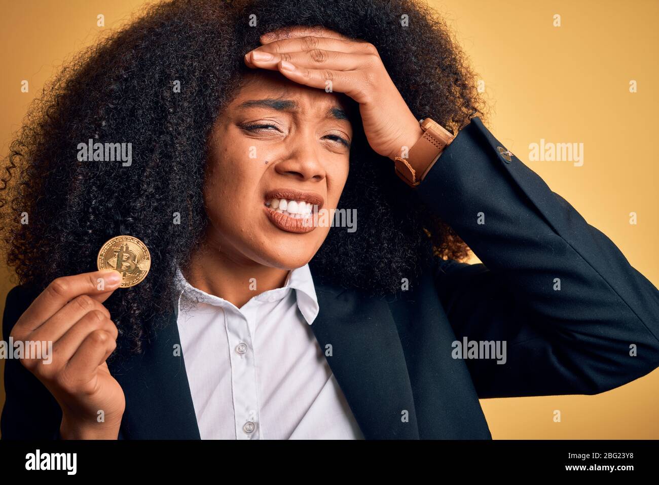 Young african american business woman with afro hair holding bitcoin over  yellow background stressed with hand on head, shocked with shame and  surpris Stock Photo - Alamy