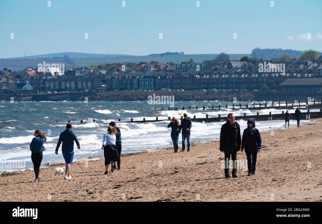 Portobello beach and promenade near Edinburgh during Coronavirus lockdown on 19 April 2020. People walking on beach. Stock Photo