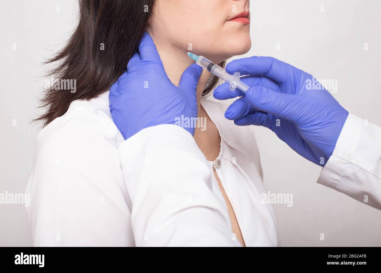 Taking a biopsy from a girl from the salivary gland to check for a benign or malignant tumor, cancer, therapy Stock Photo