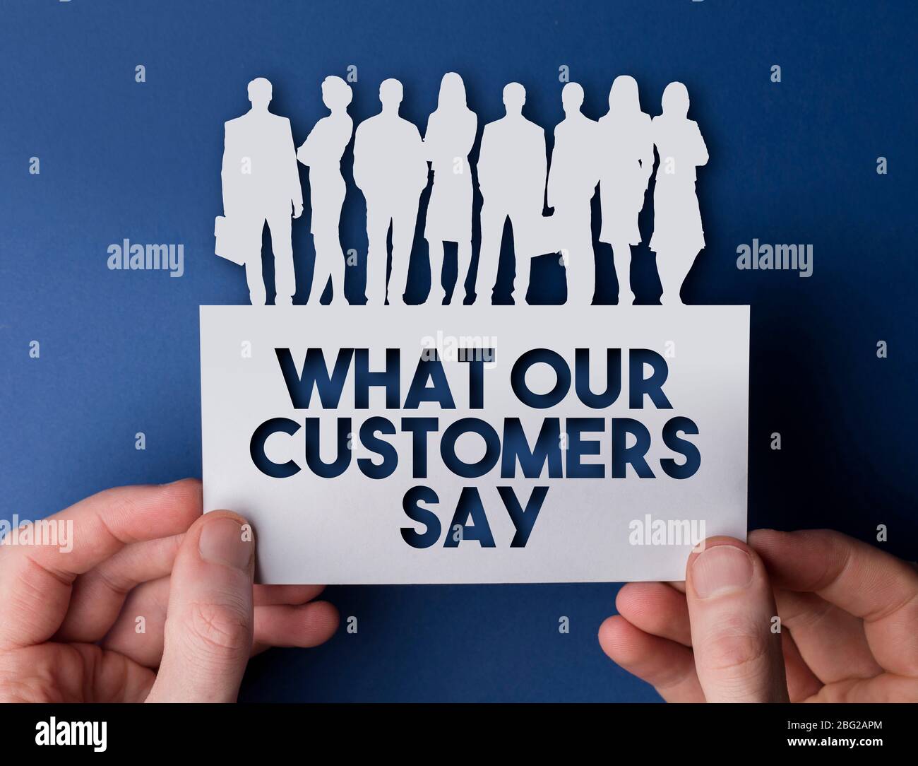 Hands holding a customer focus white card business team people sign Stock Photo