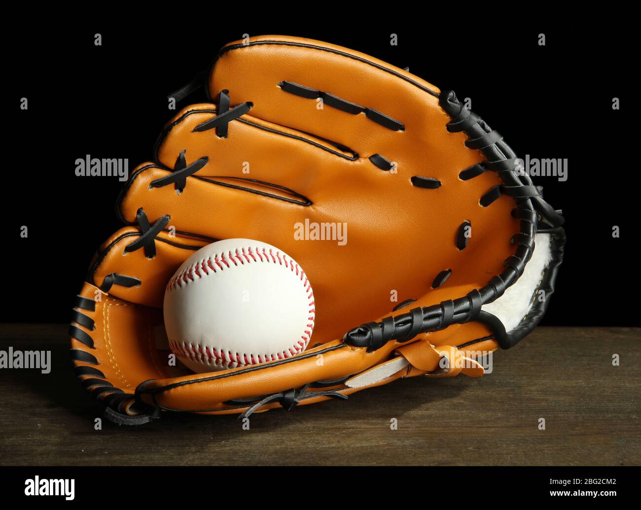 Baseball glove and ball on dark background Stock Photo - Alamy