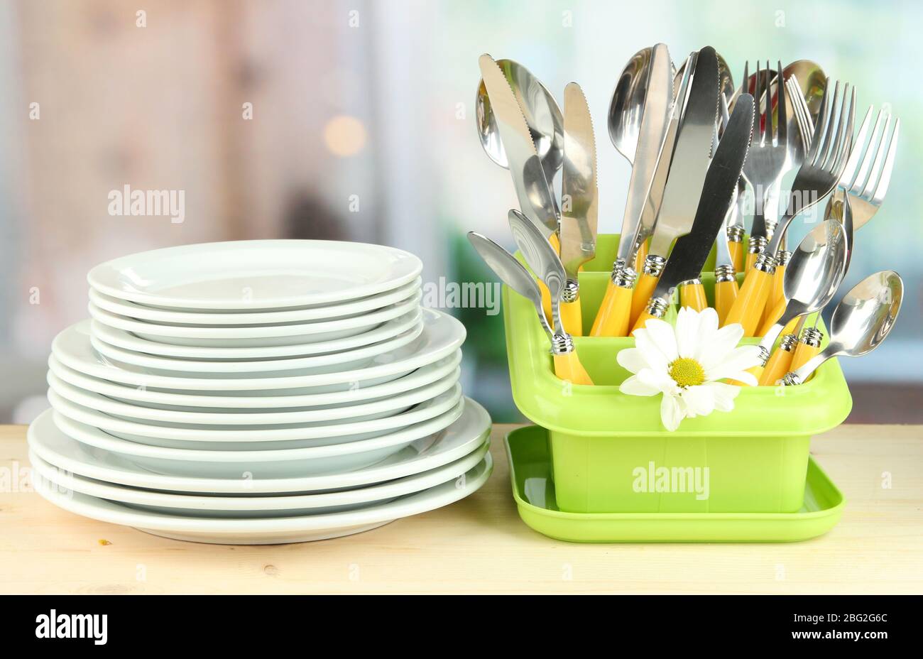 Plates, forks, knives, spoons and other kitchen utensil on bright