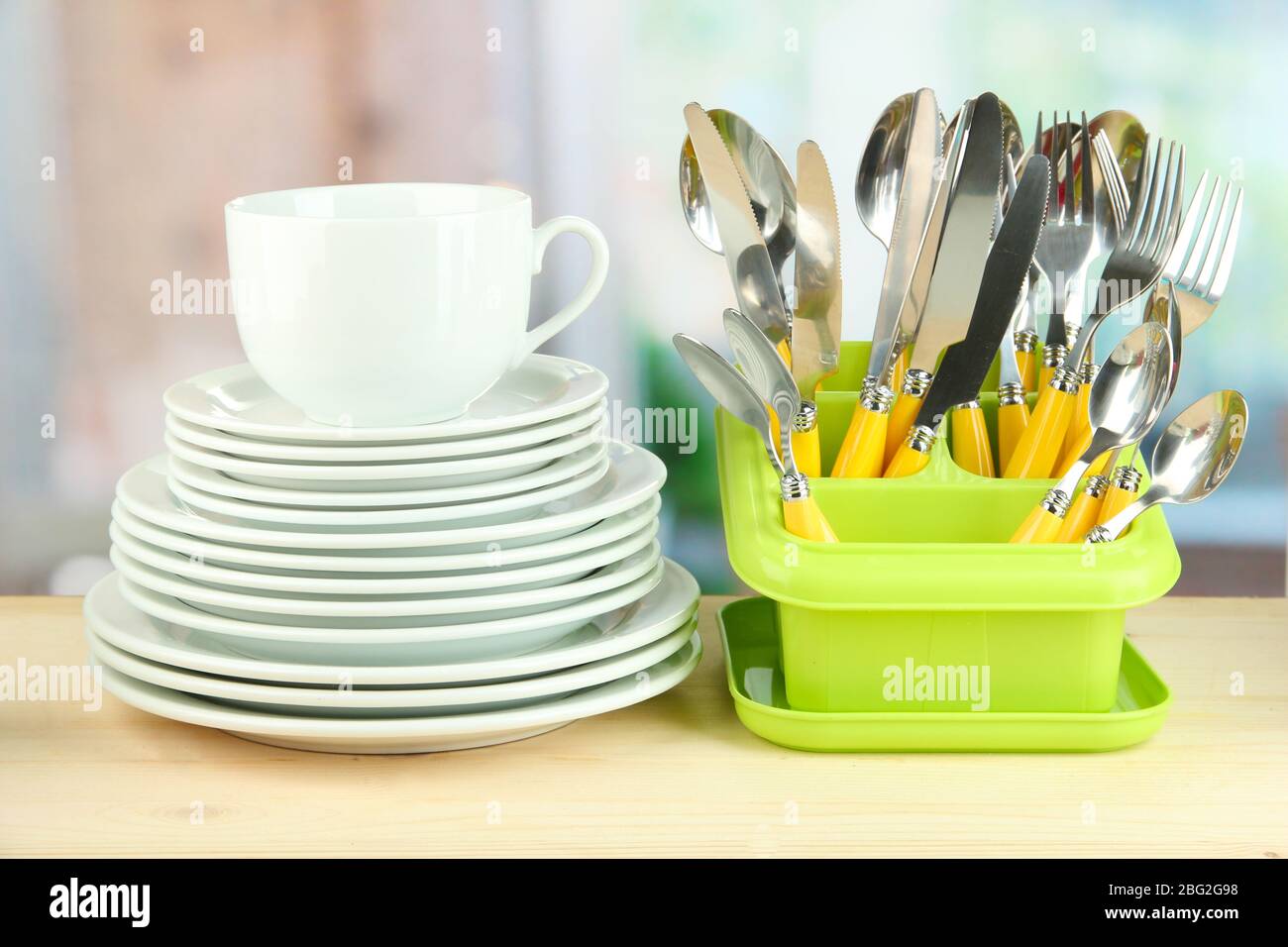 Plates, forks, knives, spoons and other kitchen utensil on bright