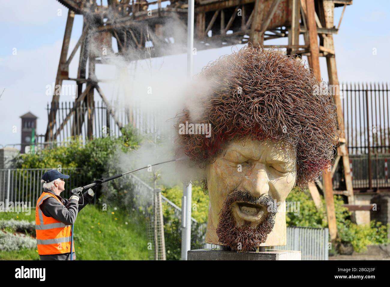 Ross Sheridan of P.Mac Cleaning and Restoration services working on behalf of Dublin City Council cleans a statue of the late musician Luke Kelly in the Sherriff street area of Dublin, after it was defaced for the fourth time in the past year. Stock Photo