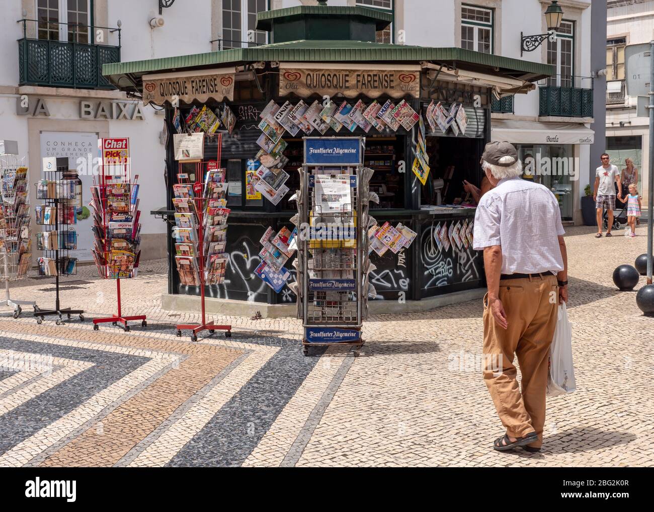 Portuguese News Kiosk. An elderly local approaches a typical news kiosk in the Algarve district of central Faro. Stock Photo