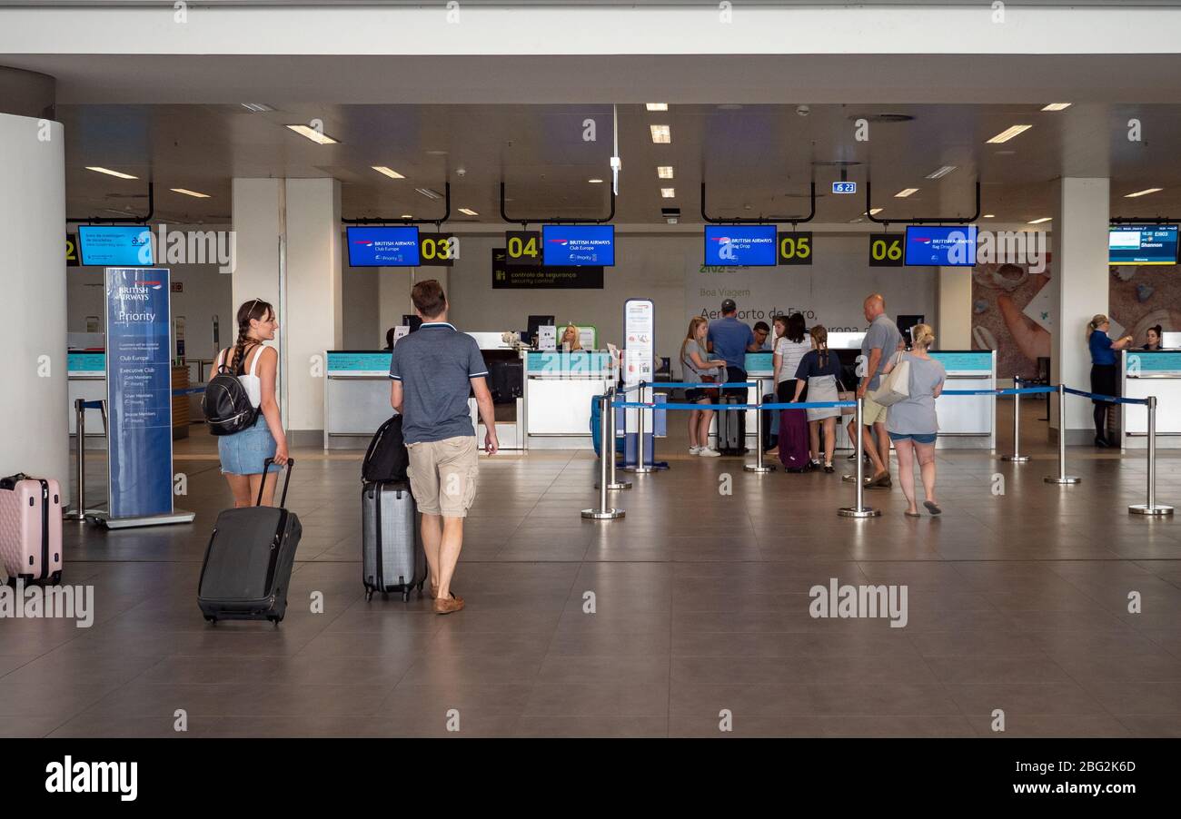 Tourists walking to the British Airways checkin desk at Faro International Airport, Portugal