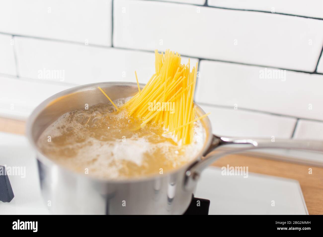 https://c8.alamy.com/comp/2BG2MMH/spaghetti-in-pan-cooking-in-boiling-water-on-a-gas-stove-yellow-gluten-free-corn-pasta-2BG2MMH.jpg