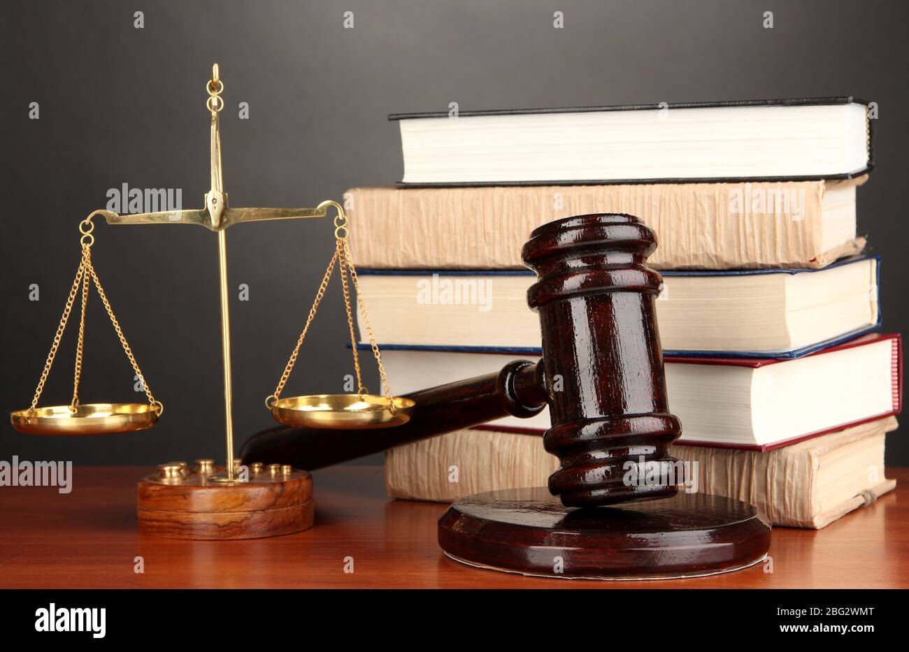 Wooden gavel, golden scales of justice and books on grey background ...