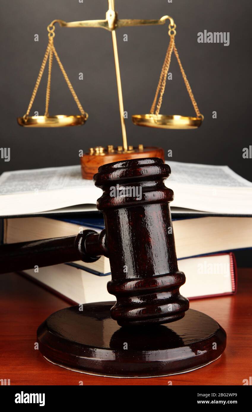 Wooden gavel, golden scales of justice and books on grey background ...
