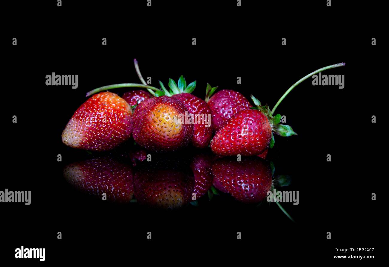 Closeup group of strawberries with reflection on ground Stock Photo - Alamy