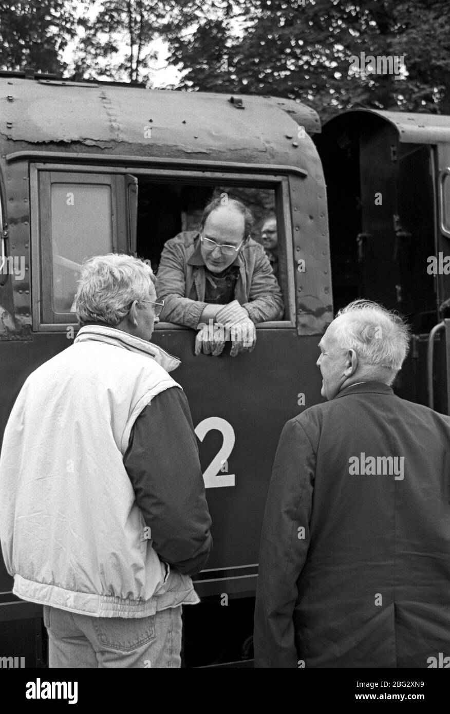 Train enthusiasts talking to steam driver on the heritage