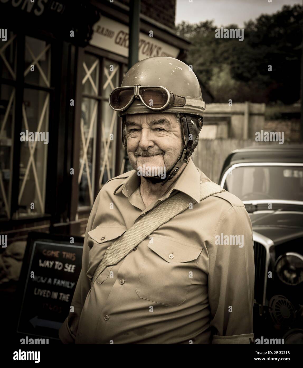 Close up of senior man dressed in 1940s costume as vintage motorcycle dispatch rider, military messenger, Black Country Museum, 1940s wartime event UK. Stock Photo
