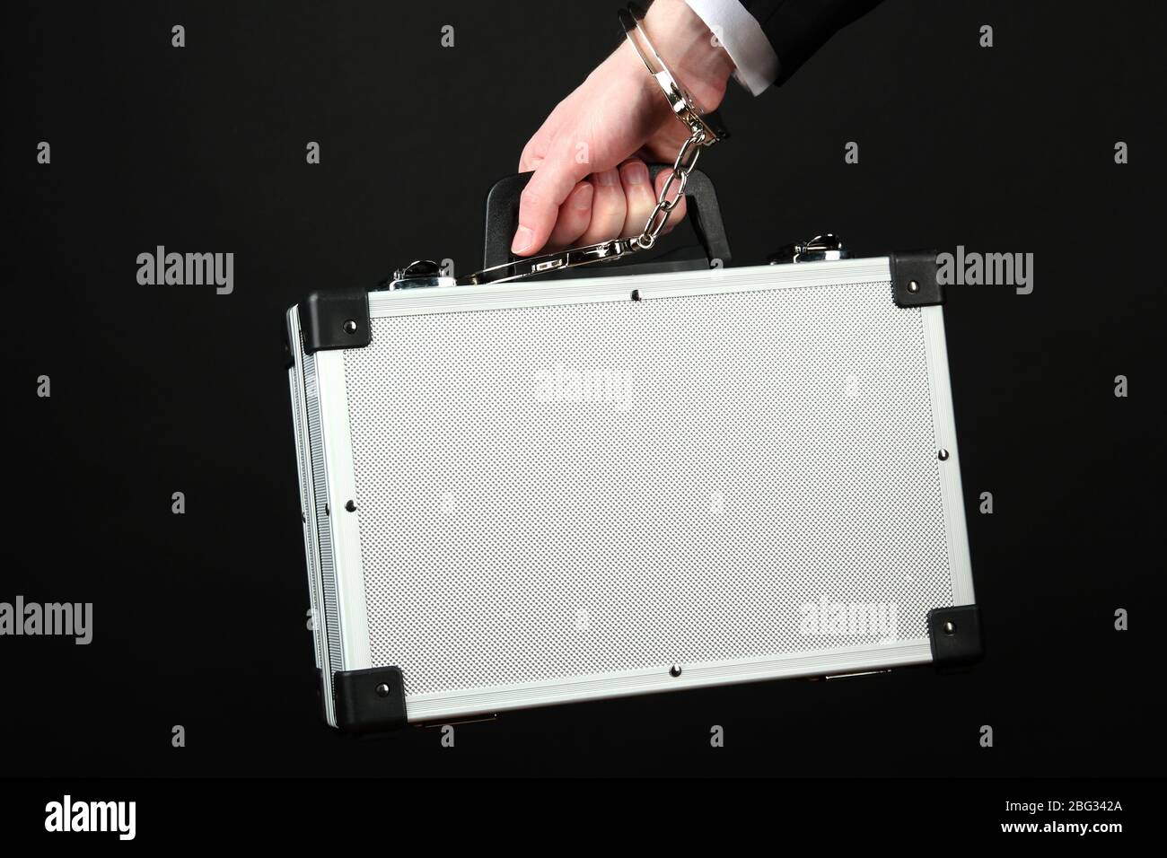 Hand with handcuff and suitcase, isolated on black Stock Photo - Alamy