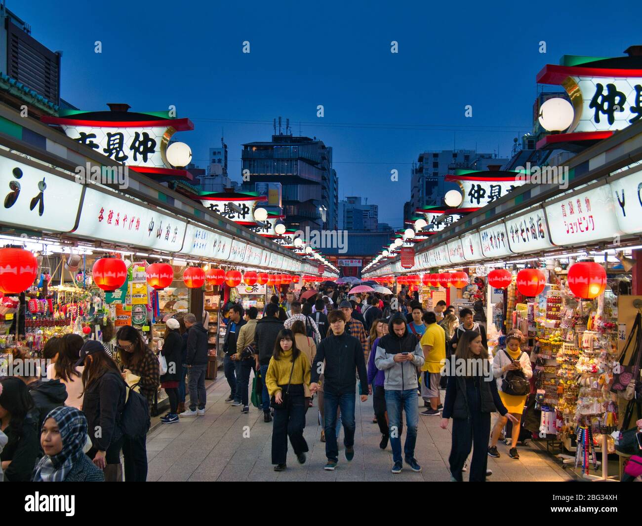 Tourists in the popular Nakamise Shopping Street near the Senso-ji Temple in Tokyo, Japan, taken at dusk Stock Photo