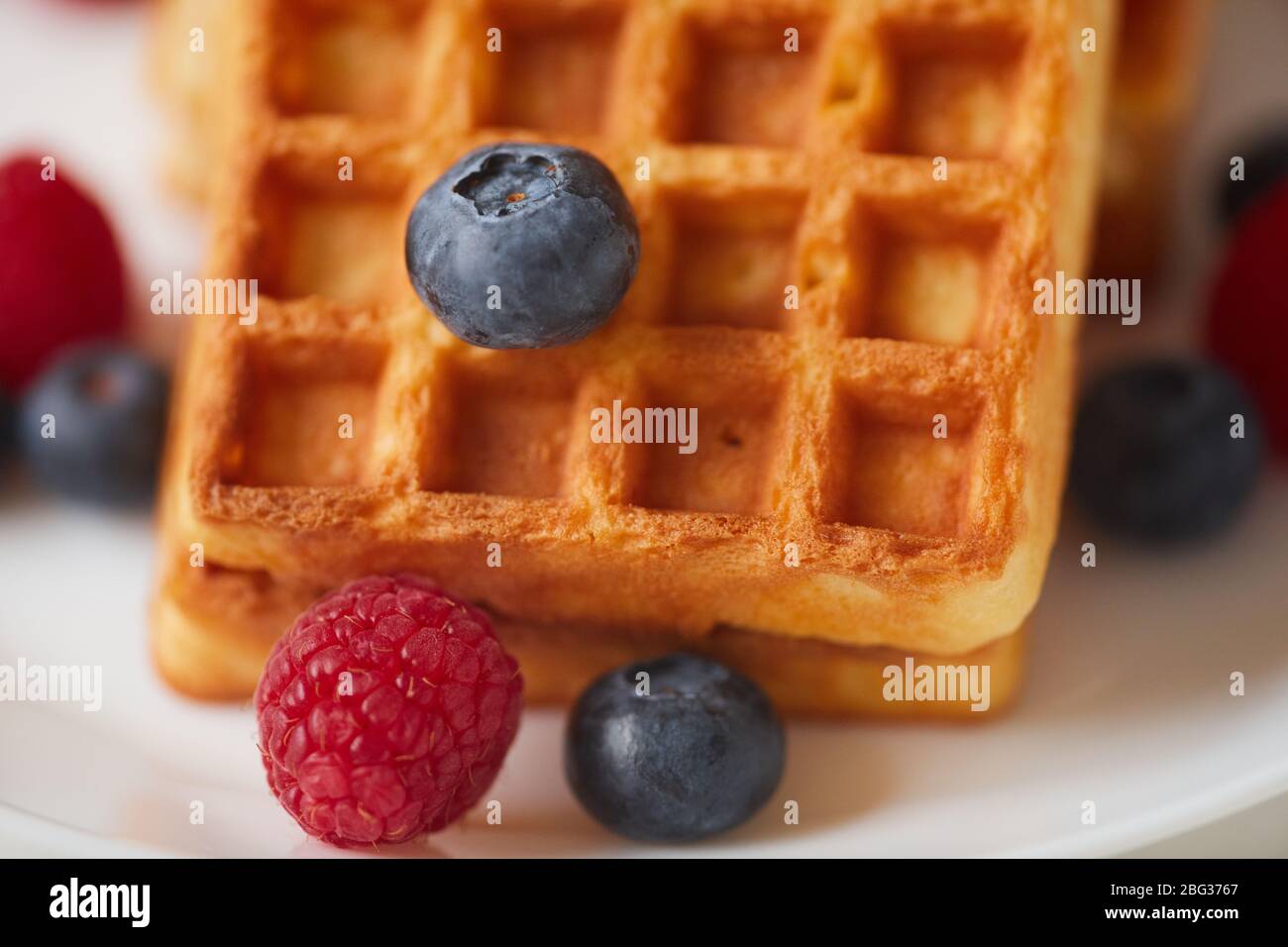 Extreme close up of fresh berries over sweet dessert waffle background, copy space Stock Photo