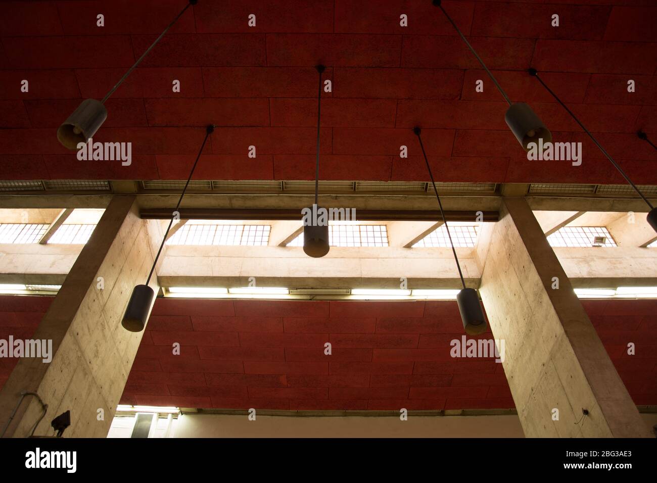 Hanging cylindrical round lights from the red ceiling Stock Photo