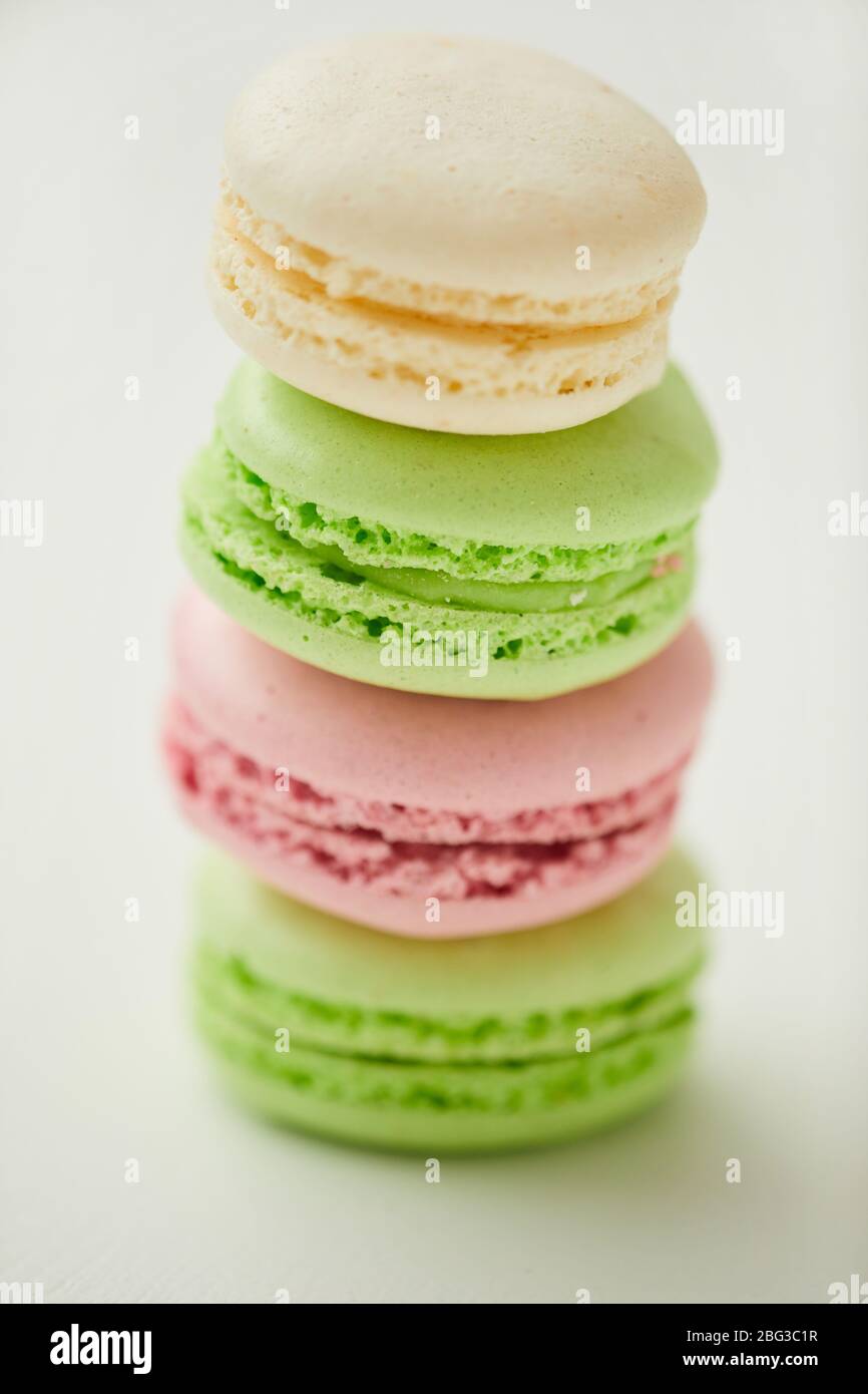Vertical close up of delicious pastel-colored macaroons stacked in row on white background Stock Photo