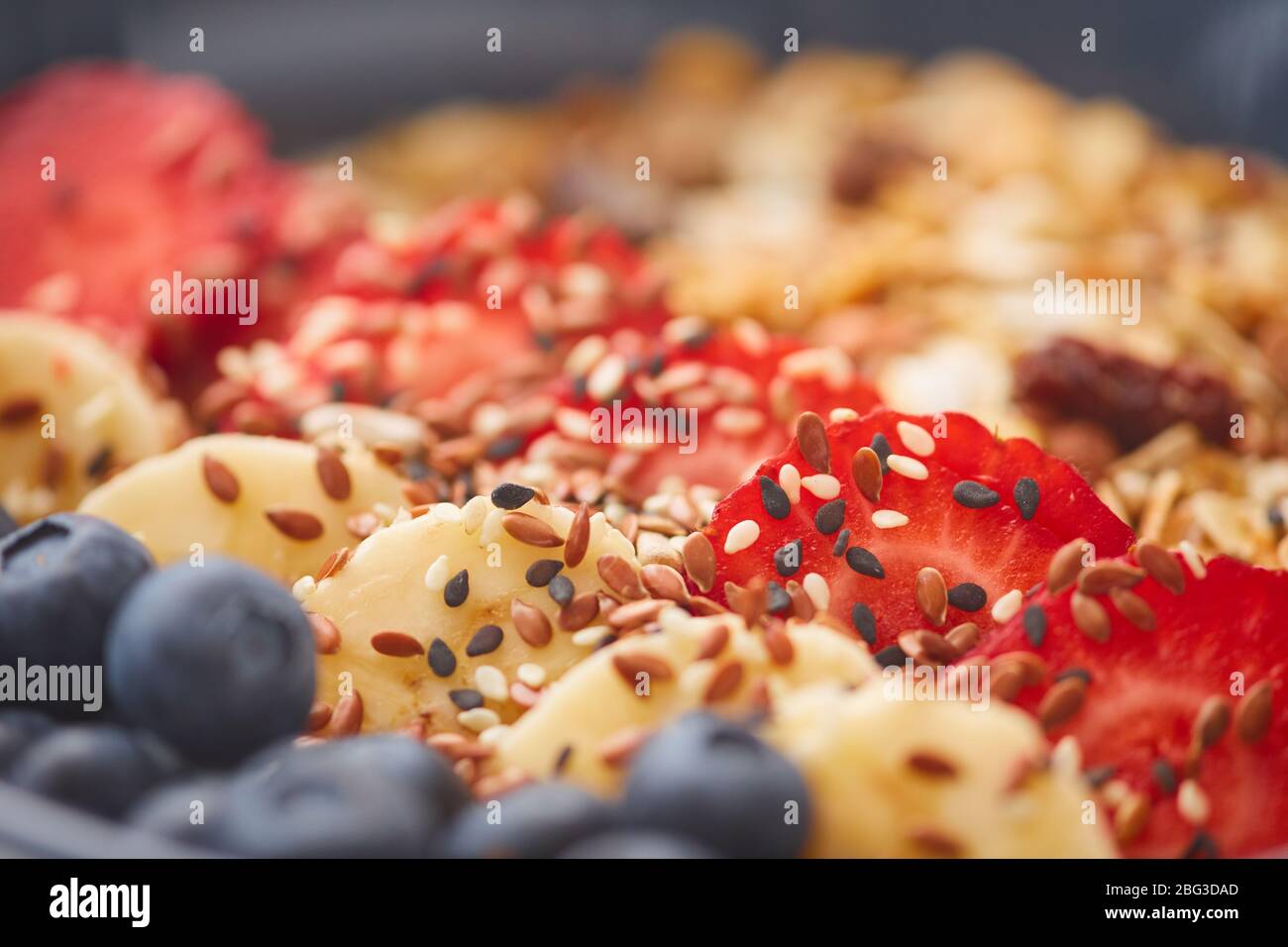 Extreme close up of delicious granola dessert decorated with fruit and berries with sesame seeds, healthy breakfast concept, copy space Stock Photo