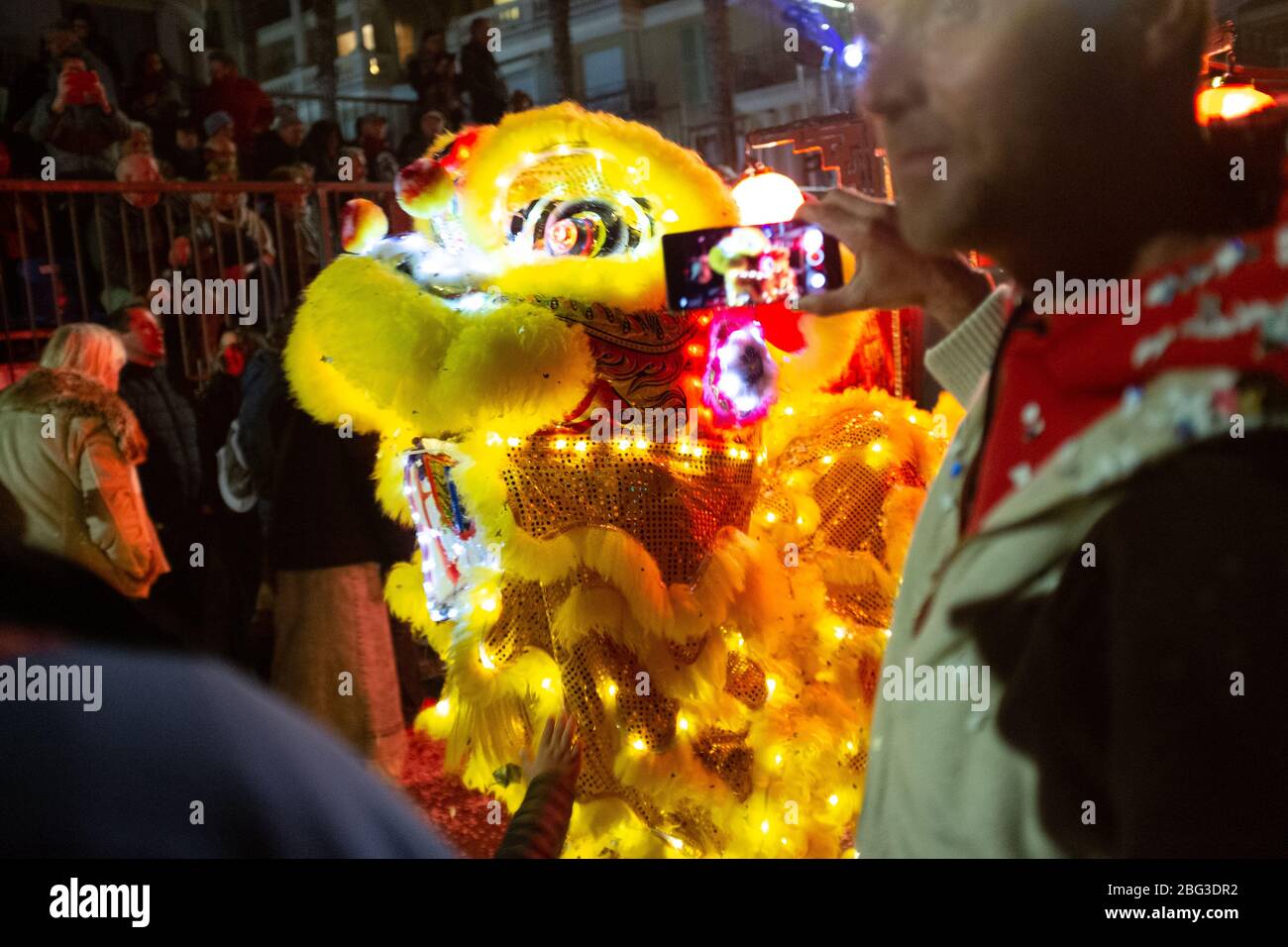 Onlookers photograph the dragon dance at the 87th Fête du Citron (Lemon Festival) in Menton, France. The festival was cancelled due to the outbreak of novel coronavirus disease (COVID-19) Stock Photo
