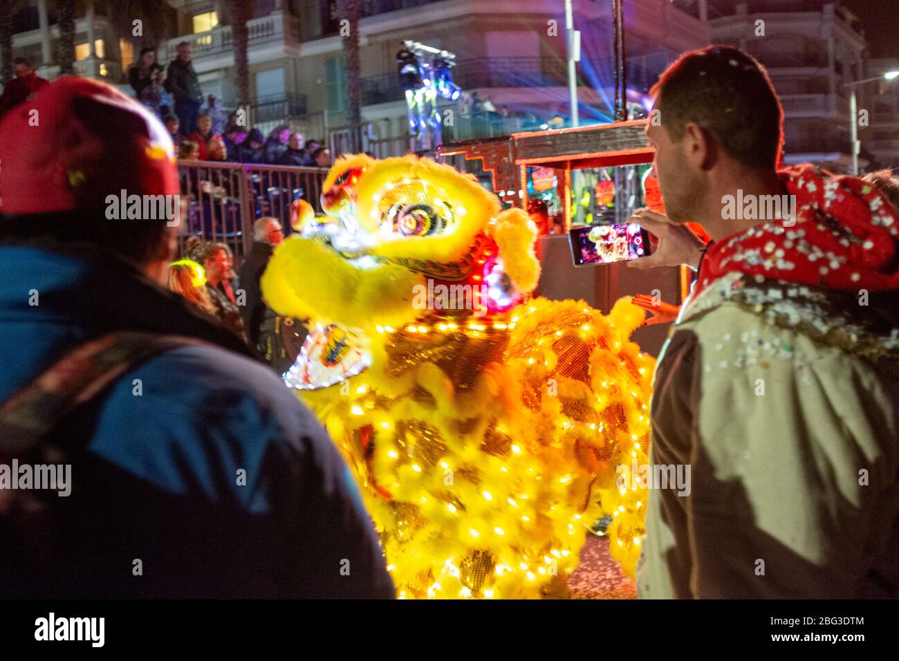 Onlookers photograph the dragon dance at the 87th Fête du Citron (Lemon Festival) in Menton, France. The festival was cancelled due to the outbreak of novel coronavirus disease (COVID-19) Stock Photo