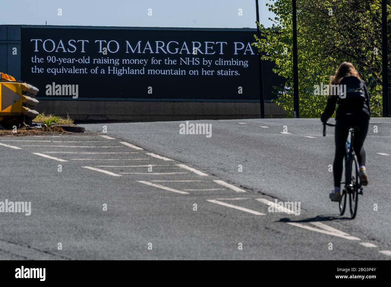 London, UK. 20th Apr, 2020. An advertising hoarding raises a toast to Margaret payne, a 90 year old raising money for teh NHS by 'climbing' a scottish mountain on her stairs at home. Credit: Guy Bell/Alamy Live News Stock Photo