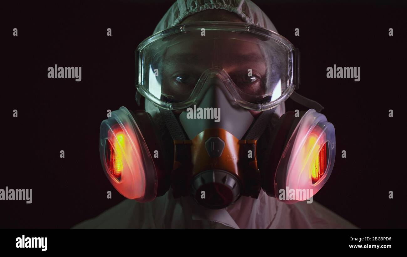 Man in protective costume suit, gas protect medical spray paint mask. Doctor in respirator. Concept health virus coronavirus epidemic. Stock Photo