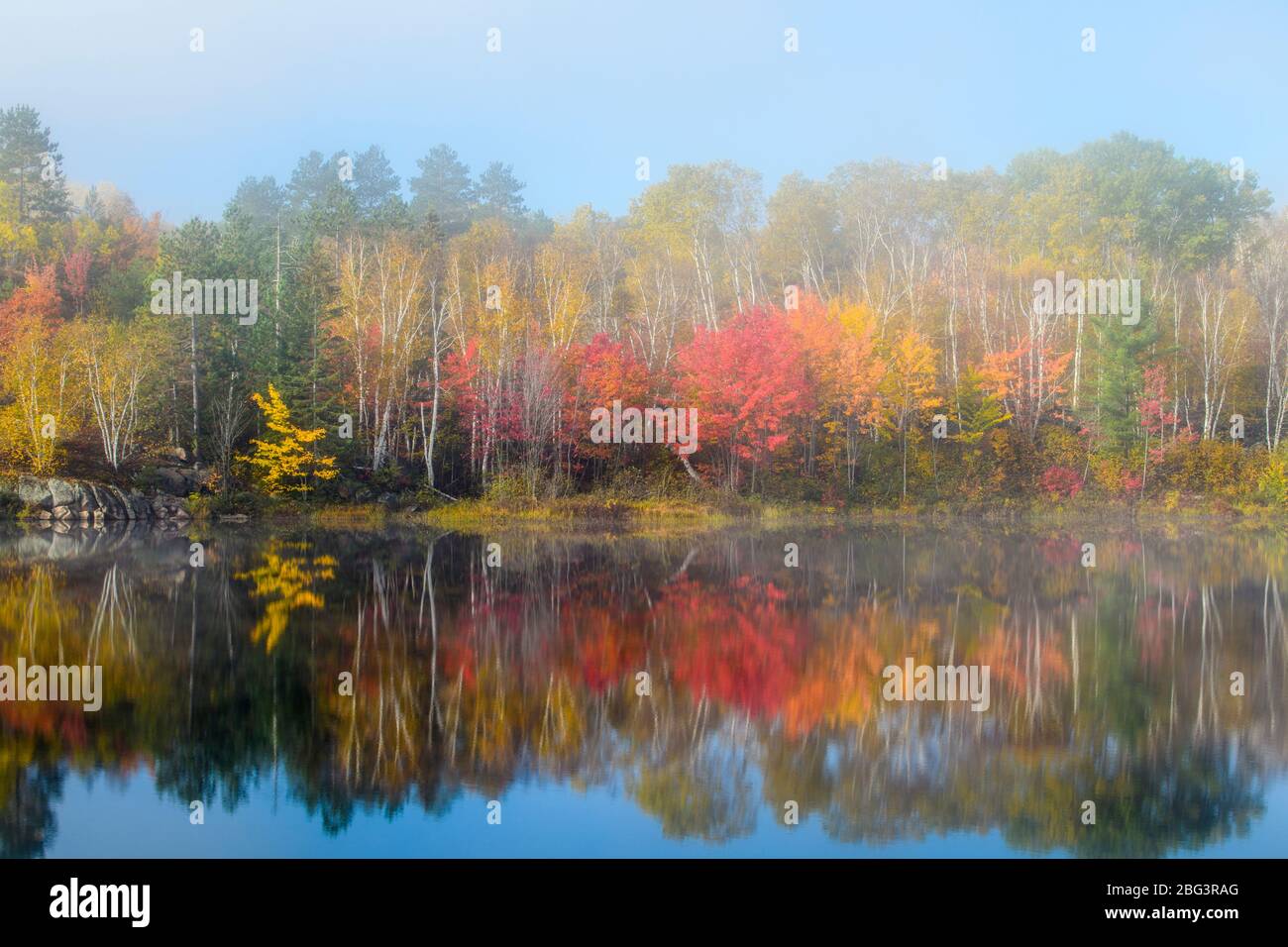 Autumn reflections in Elbow Lake with lifting fog, Greater Sudbury, Ontario, Canada Stock Photo