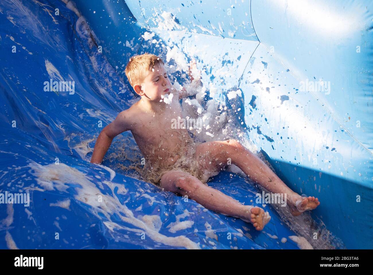 Children going down a slip and slide Stock Photo