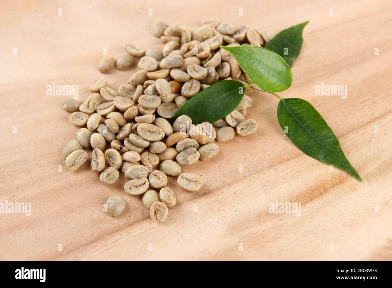 Green coffee beans and leaves on wooden background Stock Photo - Alamy
