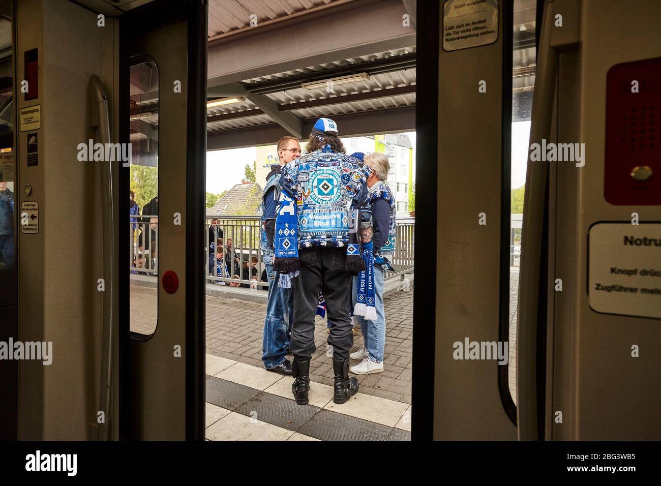 A group of football-supporters of the Hamburg football team HSV seen on the platform outside of the door of the urban railway near the Volksparkstadio Stock Photo