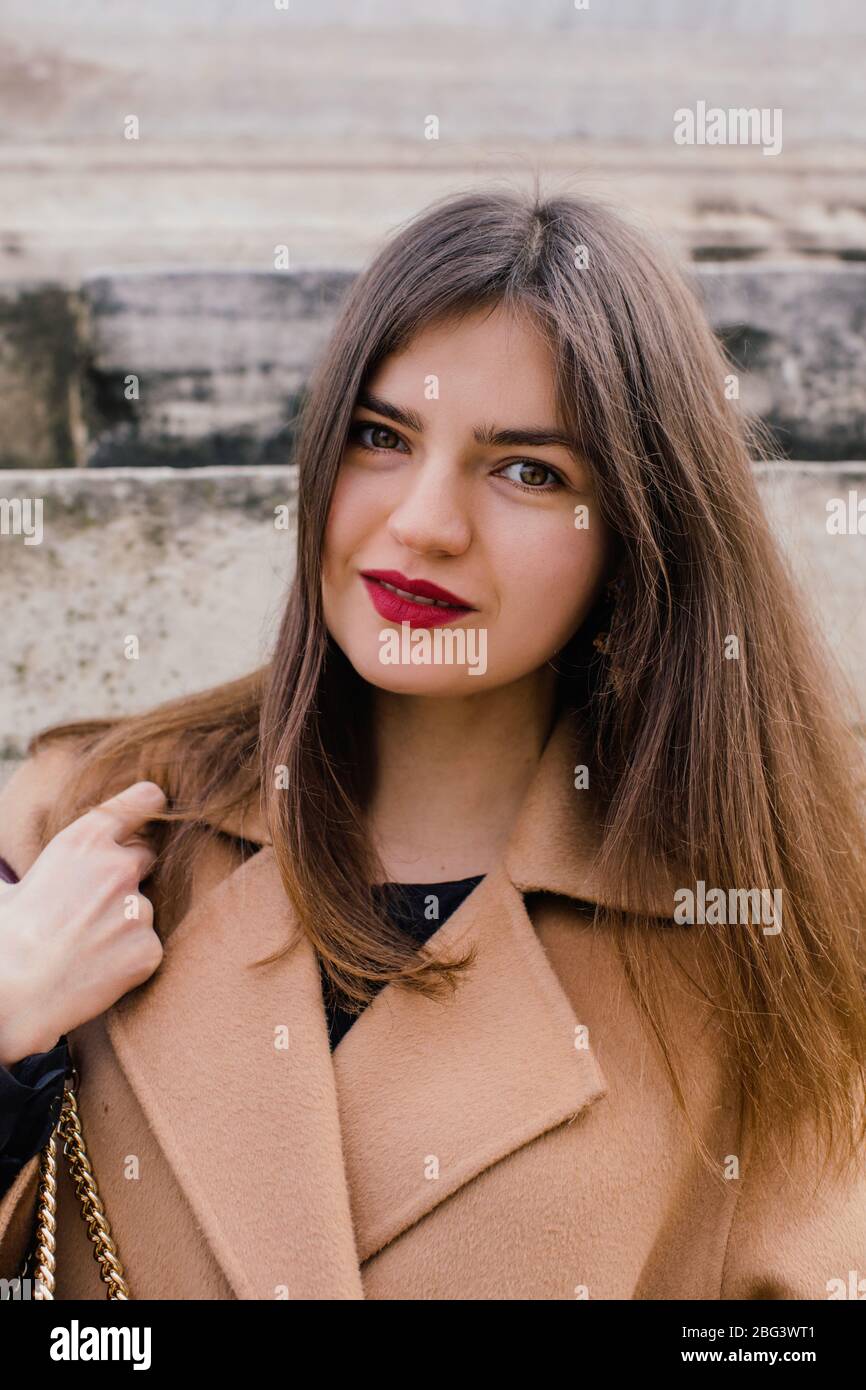 Portrait of stylish woman standing by a wall waiting, Rome, Lazio, Italy Stock Photo