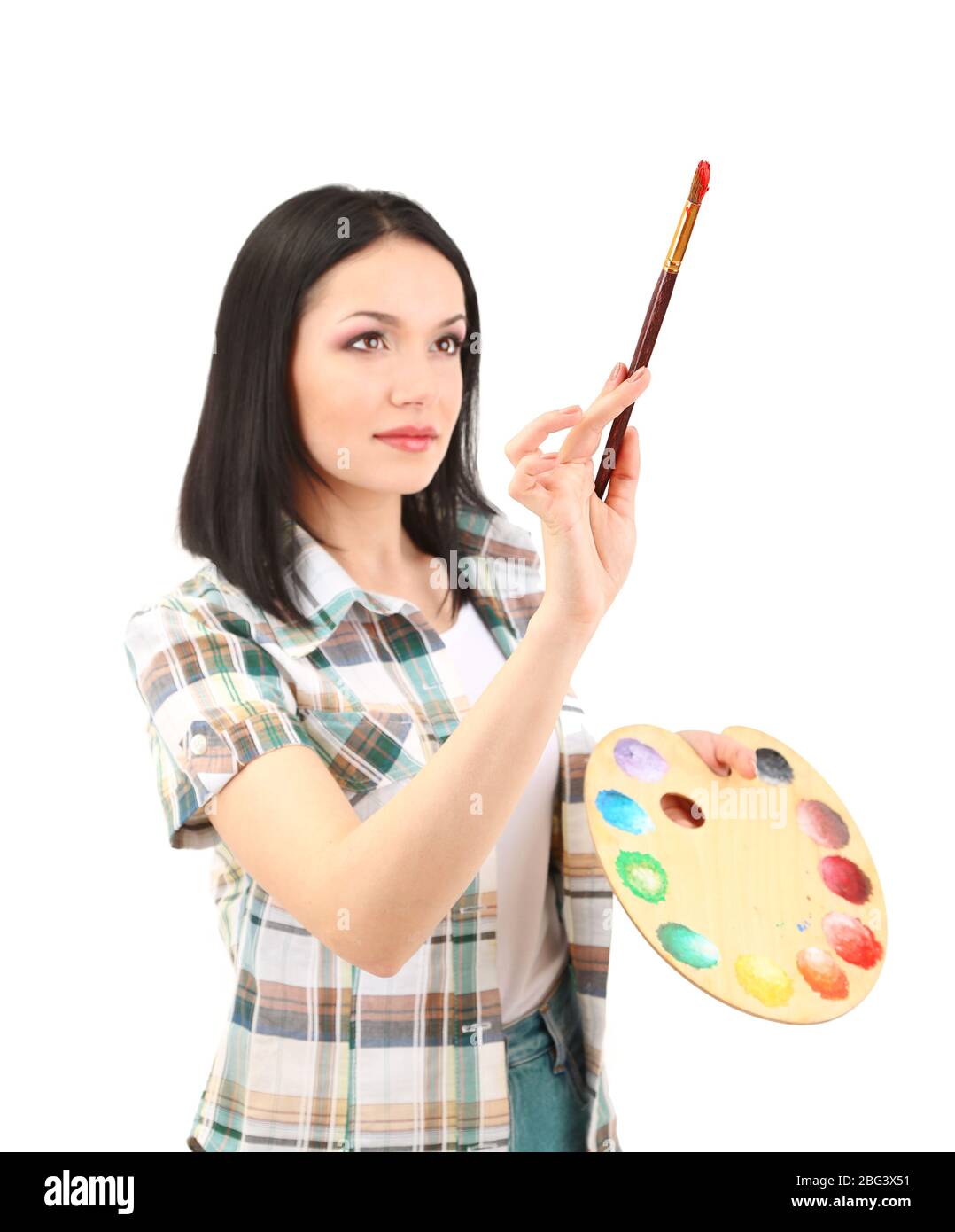 Beautiful young woman painter with brushes and palette at work ...