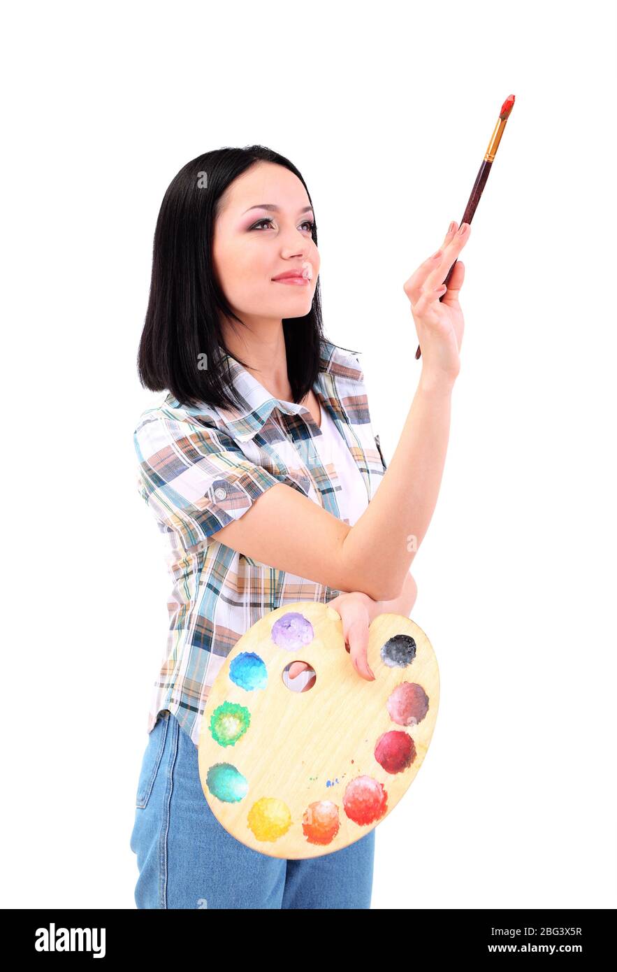 Beautiful young woman painter with brushes and palette at work ...
