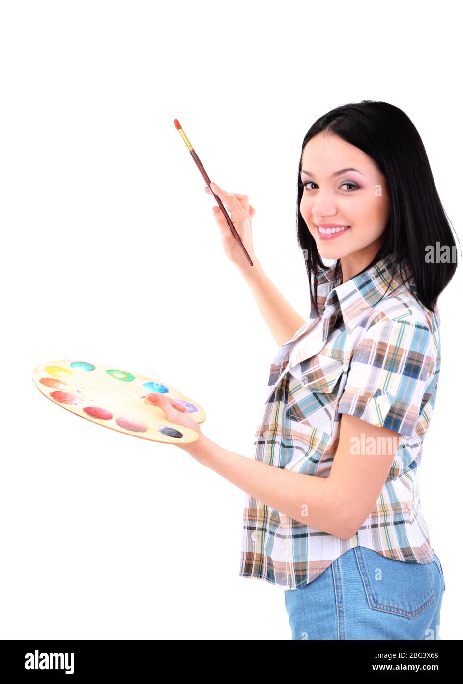Beautiful young woman painter with brushes and palette at work ...