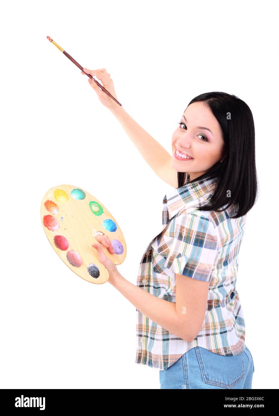 Beautiful young woman painter with brushes and palette at work ...
