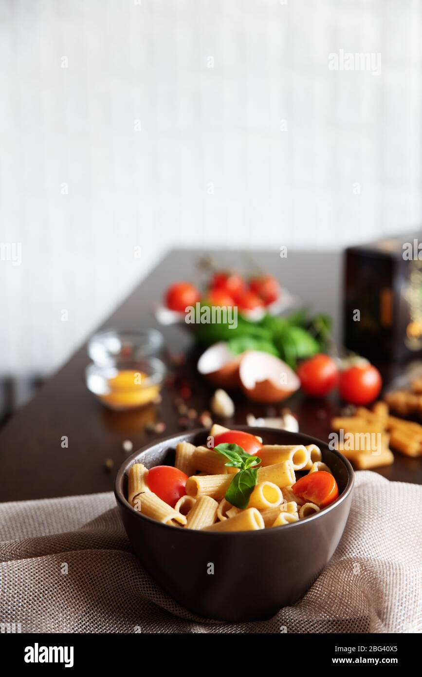 Bowl of rigatoni pasta with basil and tomato Stock Photo