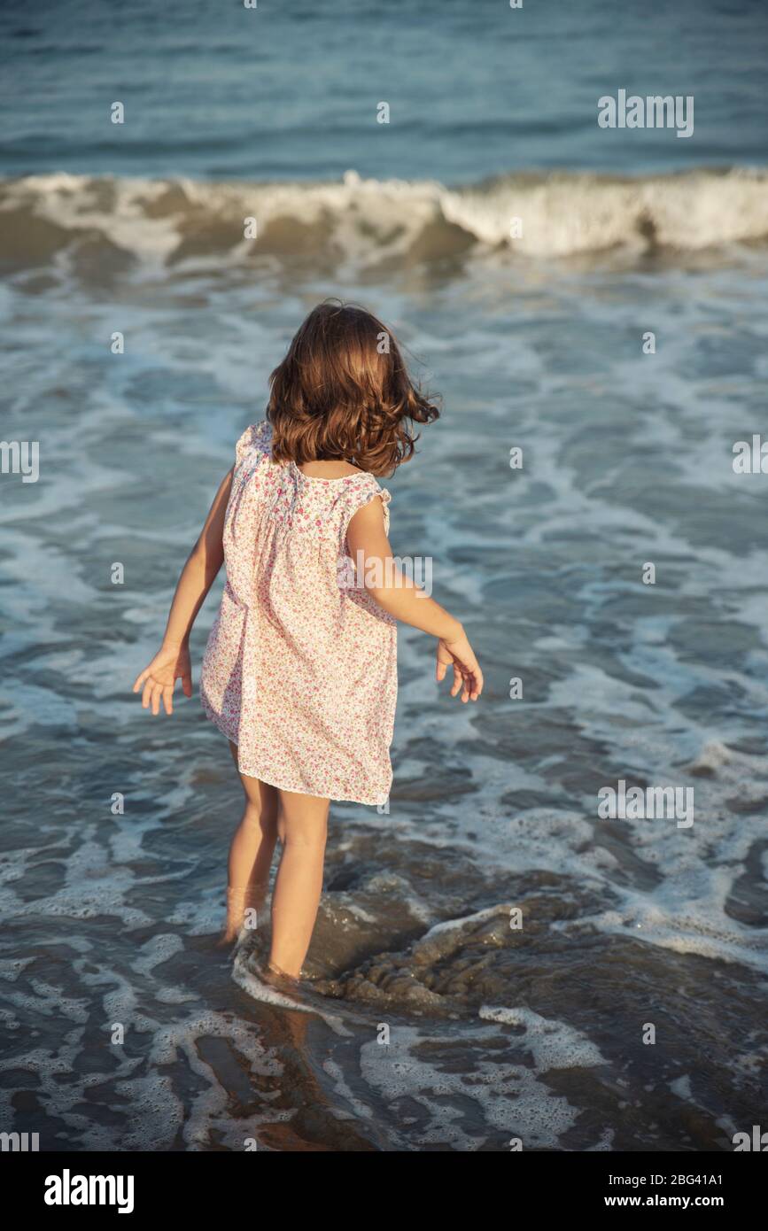 Rear view of a girl walking in the ocean surf, Bulgaria Stock Photo
