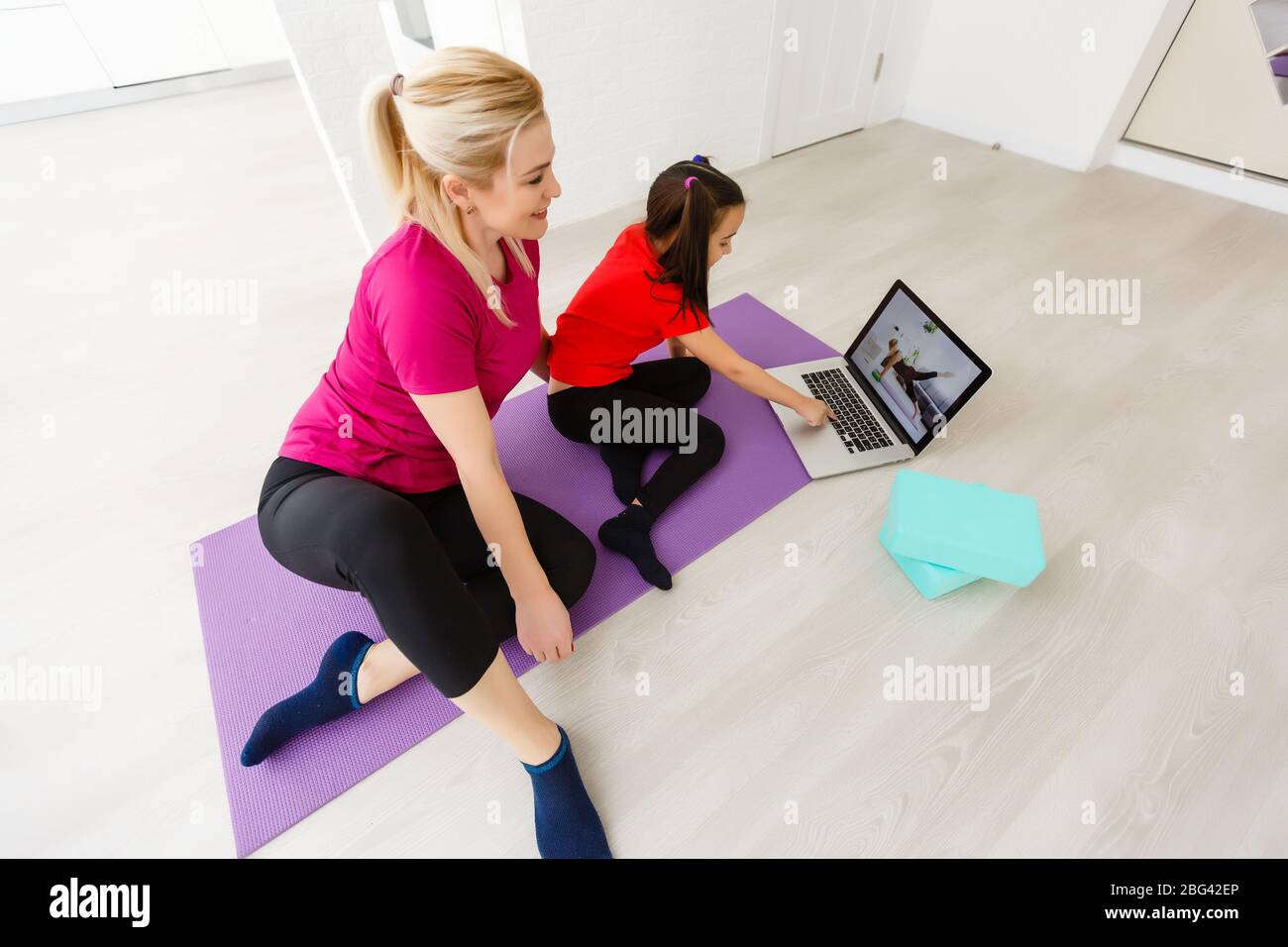 Mother and daughter doing yoga exercises on mat at home Stock Photo - Alamy