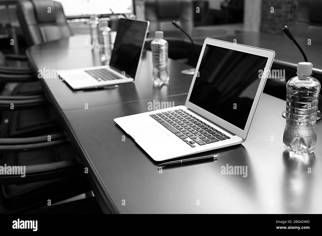 Empty conference room with laptops on table in shades of grey Stock Photo