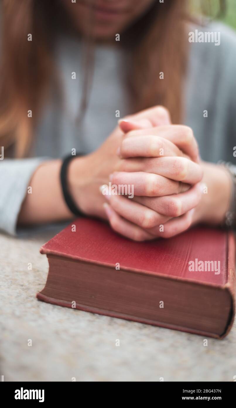 teenage girl praying , hands on bible. concept of faith & hope. Stock Photo