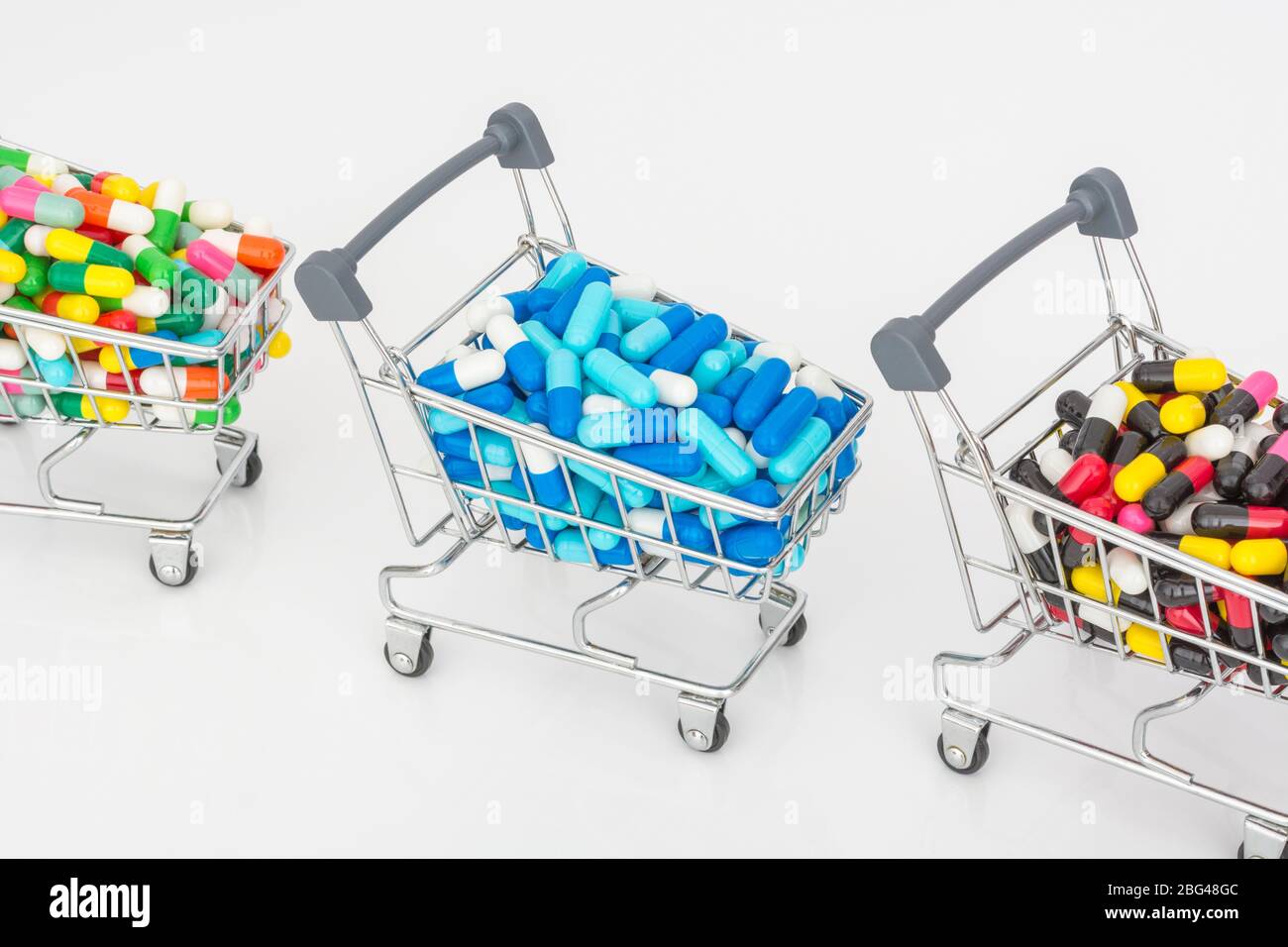 Mini shopping trolley full of colourful pills caplets. Metaphor Big