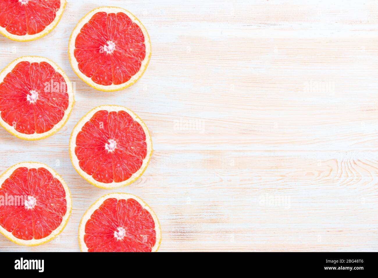 Fresh grapefruits on light blue background with copyspace Stock Photo