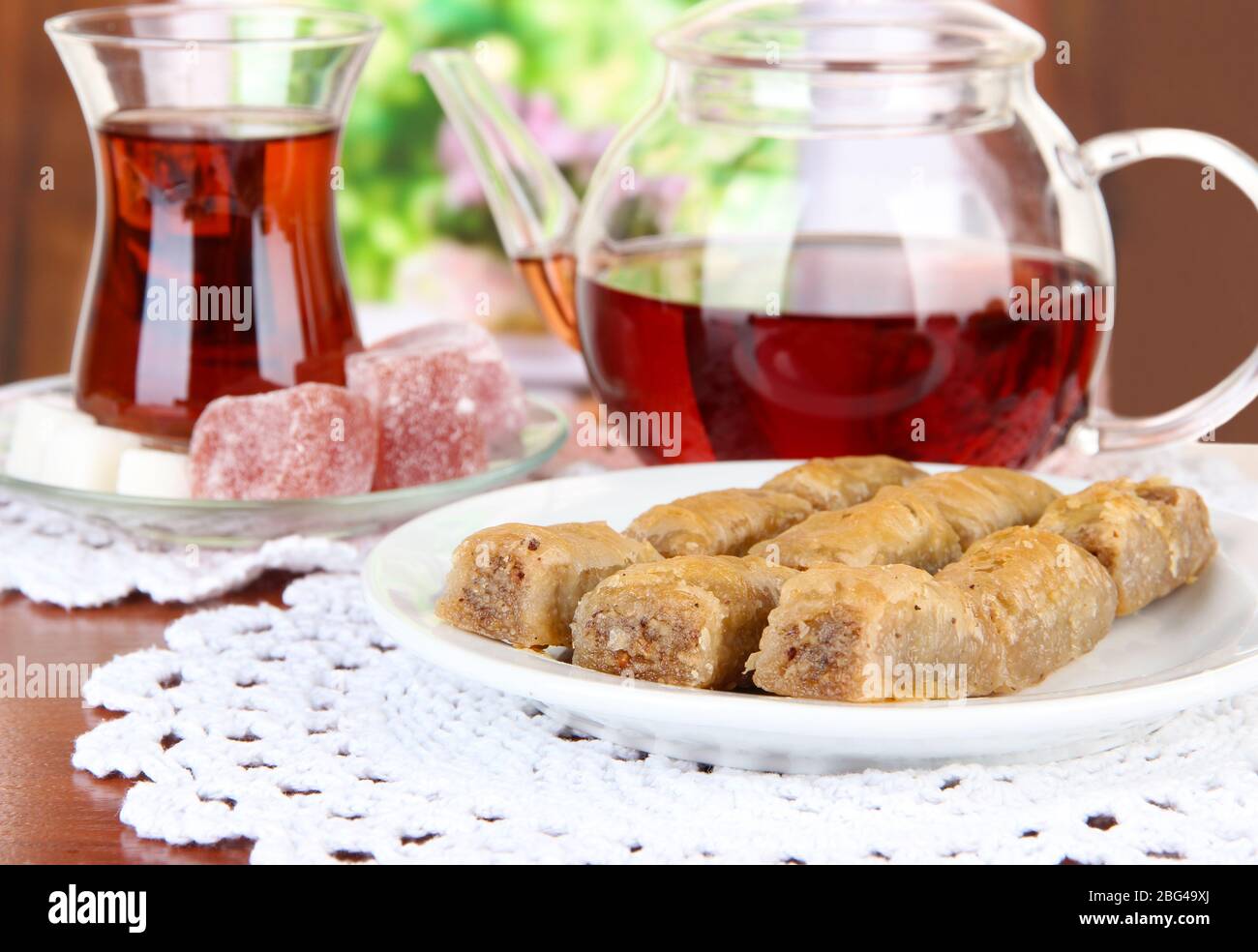Sweet baklava on plate with tea on table in room Stock Photo