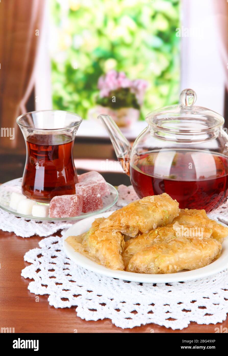 Sweet baklava on plate with tea on table in room Stock Photo